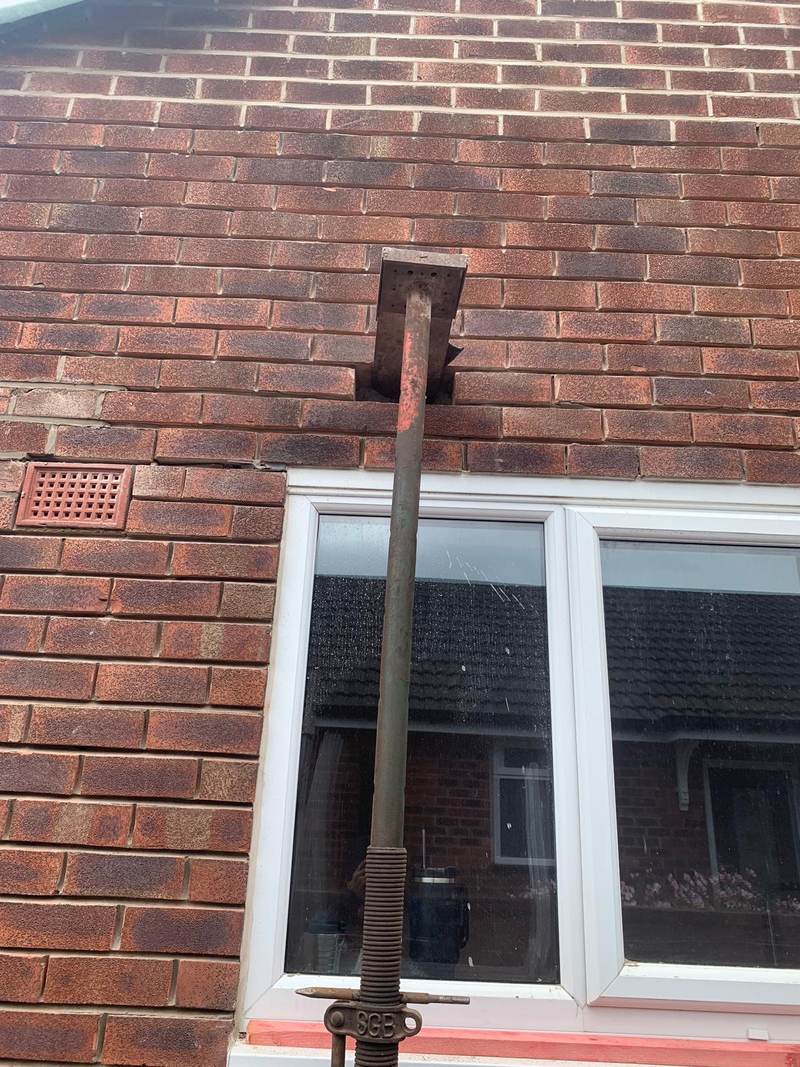 Window opening supported with a steel prop during brickwork repairs in Bolton